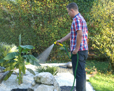 Mann der einen Garten gießt